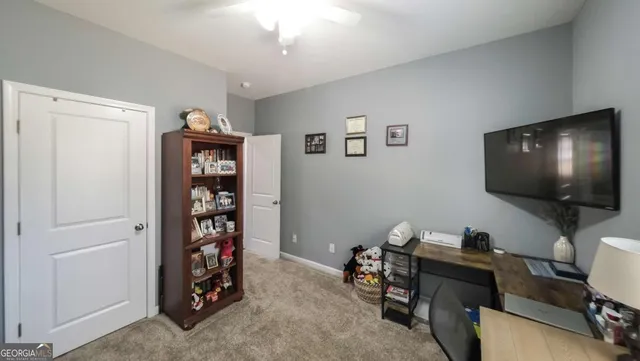 a view of a workspace with furniture and a window