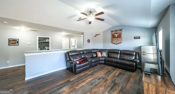 a living room with furniture a fireplace and a ceiling fan