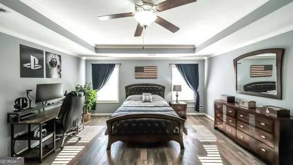 a bedroom with a bed next to a window and a chandelier