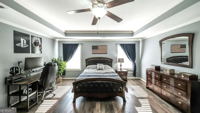 a bedroom with a bed next to a window and a chandelier