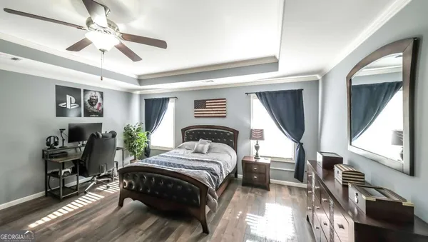 a bedroom with a bed and a flat tv screen on dresser