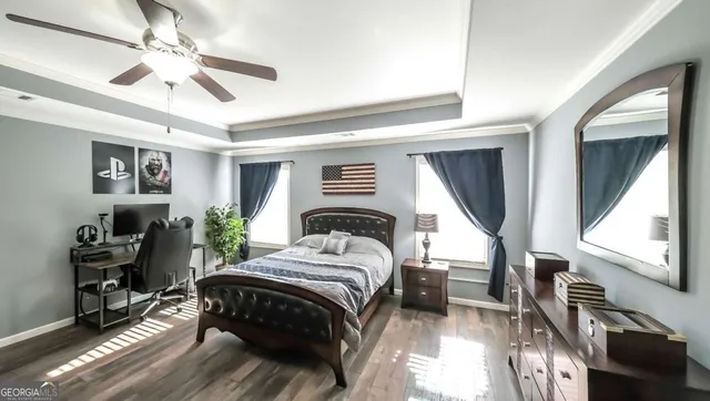 a bedroom with a bed and a flat tv screen on dresser