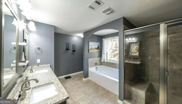 a bathroom with double vanity and a mirror