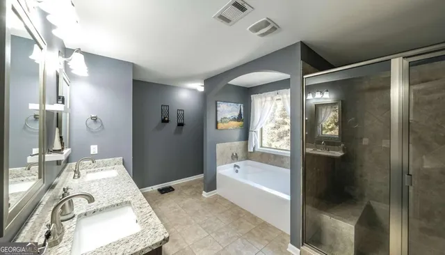 a bathroom with double vanity and a mirror
