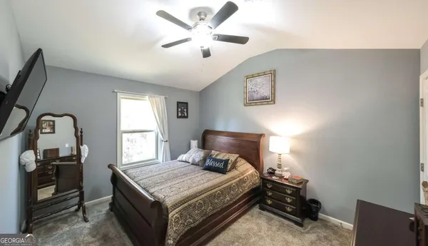 a bedroom with a bed and a tv on the dresser