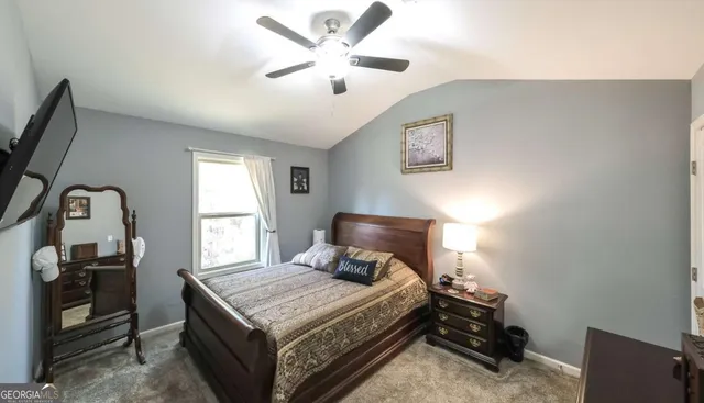 a bedroom with a bed and a tv on the dresser