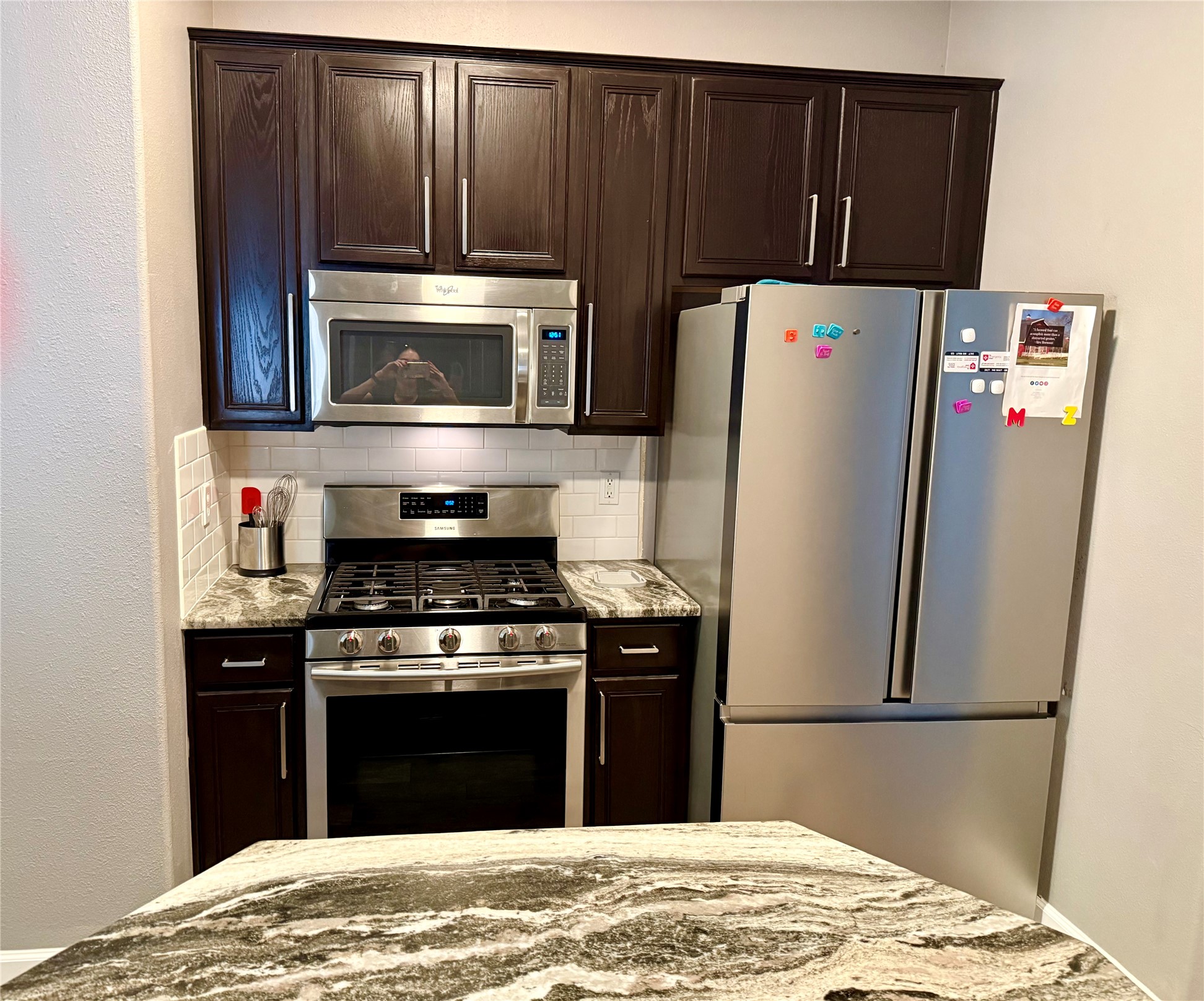 223 Maple Lane Conroe, TX 77304 - Photo 21 of 24 a kitchen with a stove and a microwave