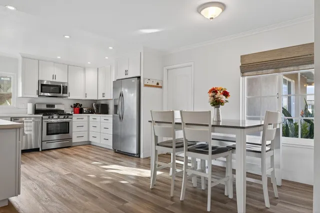 a kitchen with granite countertop a refrigerator stove microwave and cabinets