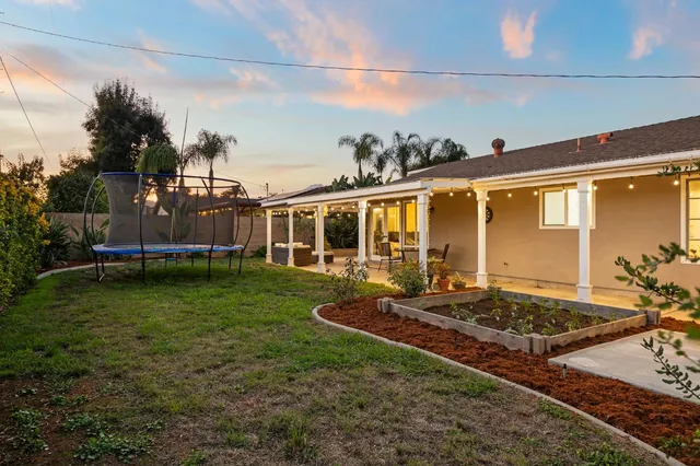 a view of a house with backyard sitting area and garden