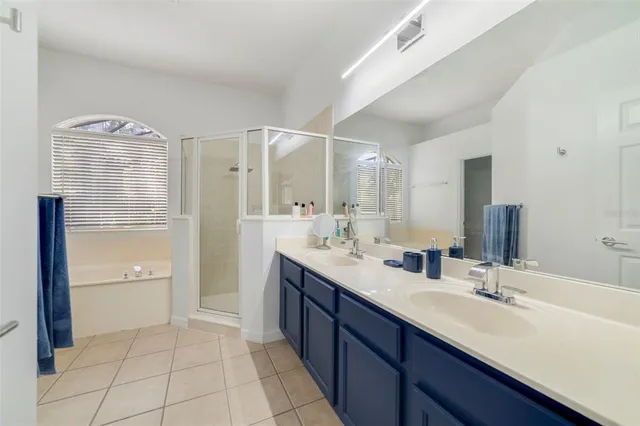 a spacious bathroom with a double vanity sink a mirror and a shower