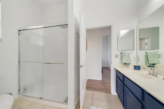 a spacious bathroom with a double vanity sink a mirror and a shower