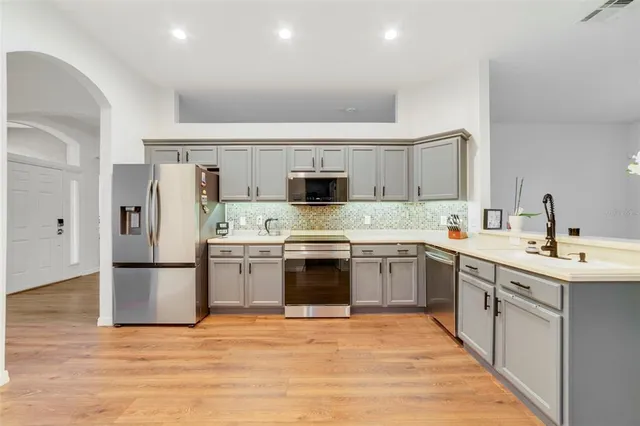 a kitchen with stainless steel appliances granite countertop a sink and refrigerator