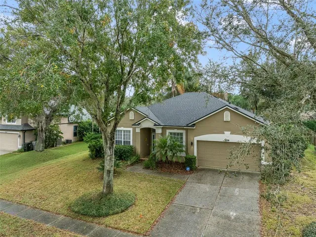 a view of a house with a yard and large tree