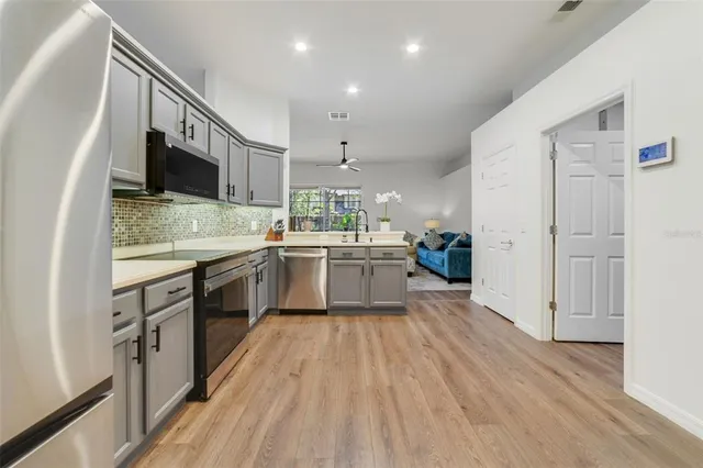 a kitchen with a sink a counter top space stainless steel appliances and cabinets