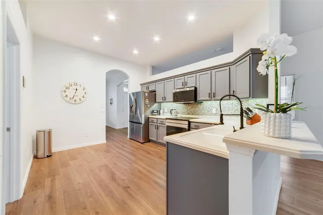 a kitchen with stainless steel appliances a sink dishwasher stove refrigerator and microwave