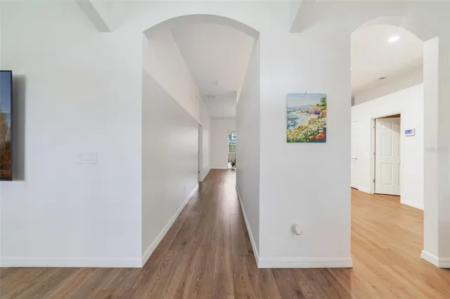 a view of a hallway with wooden floor and dining room