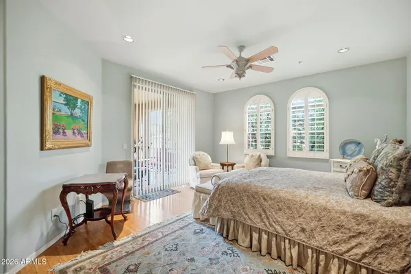a bedroom with a bed couches and wooden floor