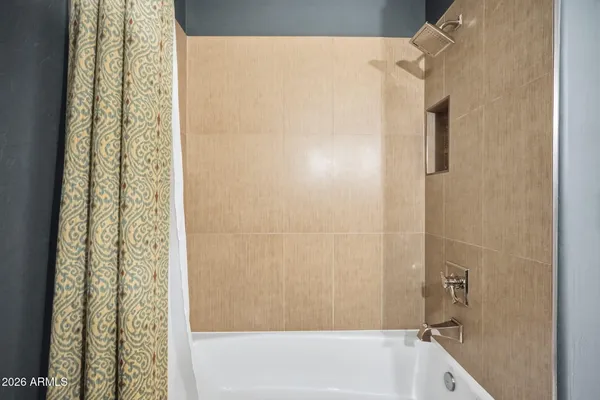 a bathroom with a tub sink and mirror