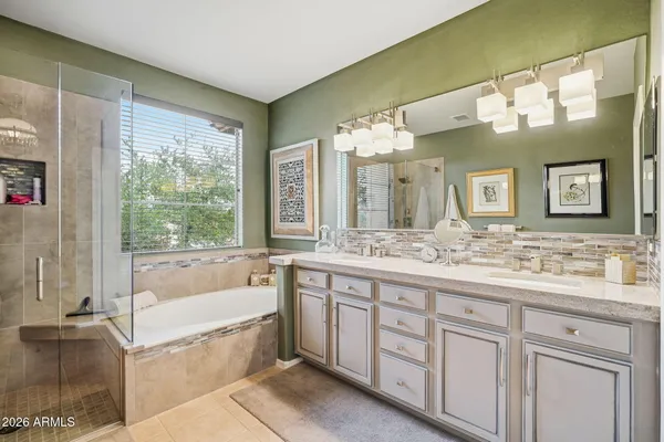 a bathroom with a granite countertop bathtub shower sink and mirror