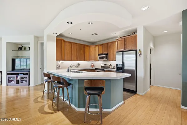 a kitchen with stainless steel appliances granite countertop a kitchen island a stove a table and chairs in it