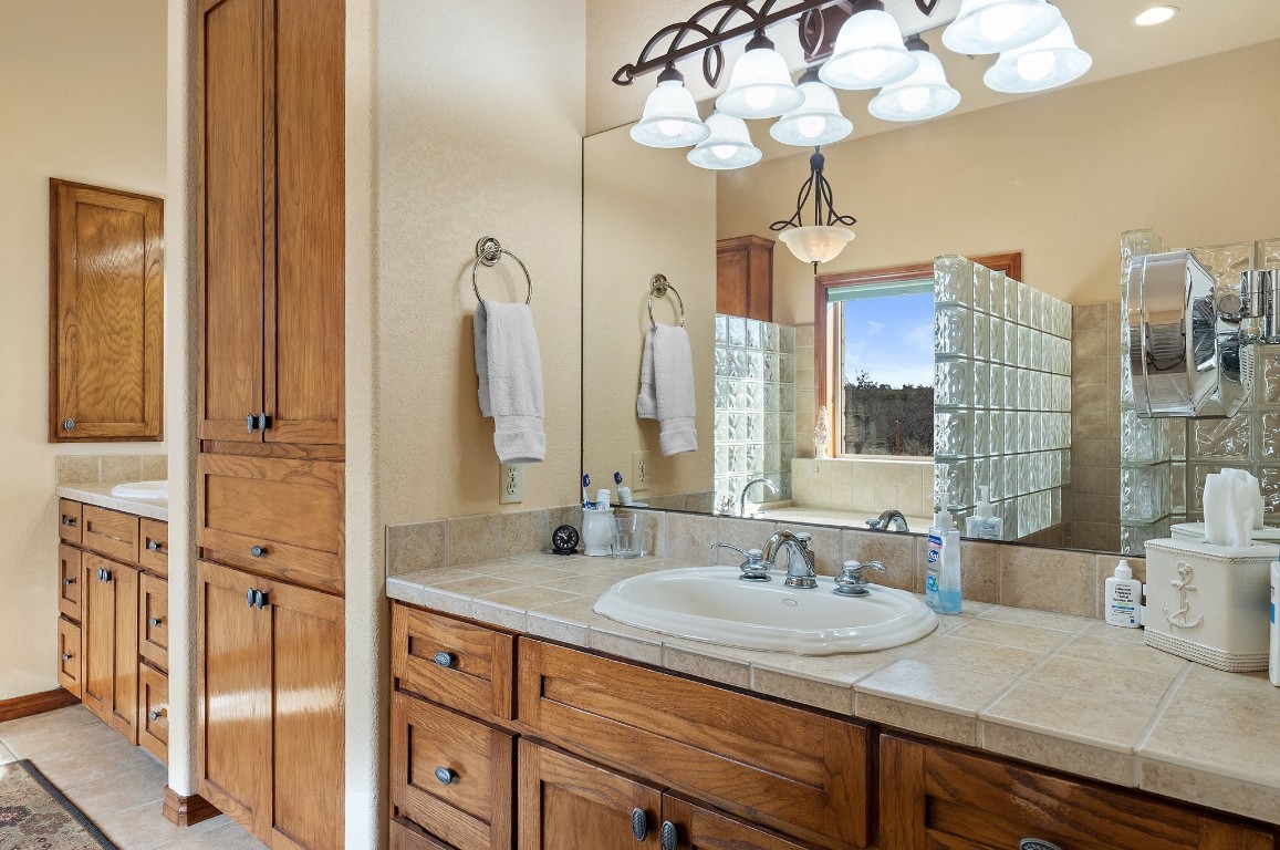 8095 Ranch To Market Road 2618 Fredonia, TX 76842 - Photo 17 of 39 a bathroom with a granite countertop sink a large mirror and shower