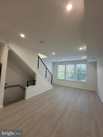 a large kitchen with stainless steel appliances kitchen island a large counter space a sink and a large window