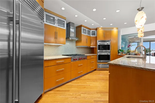 a kitchen with stainless steel appliances granite countertop a sink a stove and a refrigerator
