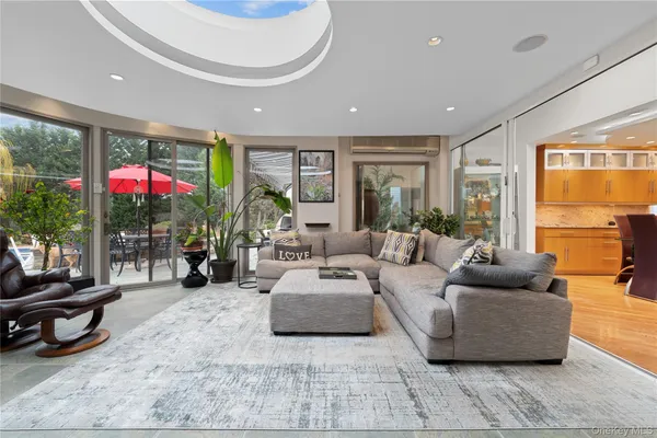 a living room with furniture and a floor to ceiling window