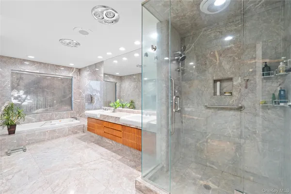 a large spacious bathroom with a glass shower door and a sink