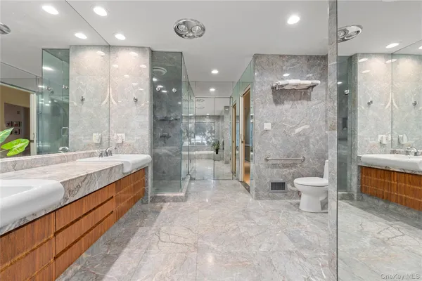 a bathroom with a double vanity sink toilet a mirror and shower