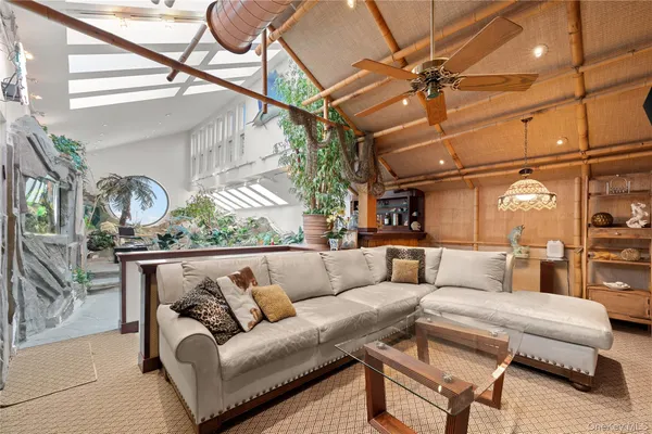 a living room with furniture a ceiling fan and a rug