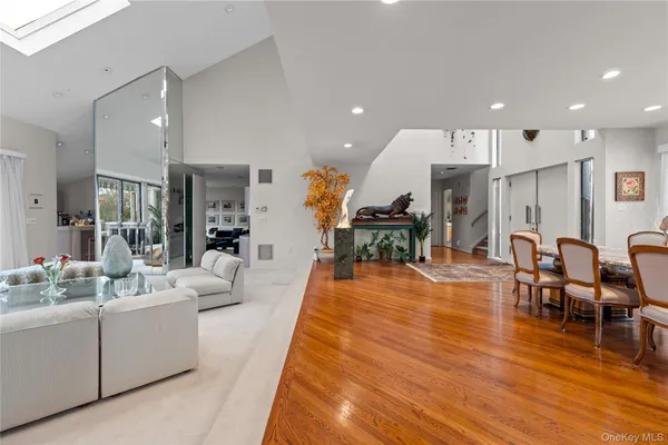 a living room with furniture a wooden floor and kitchen view