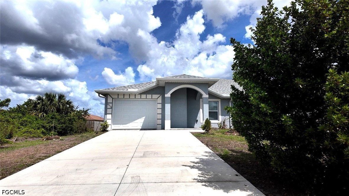 4518 14th Street Southwest Lehigh Acres, FL 33973 - Photo 2 of 6 a front view of a house with a garden