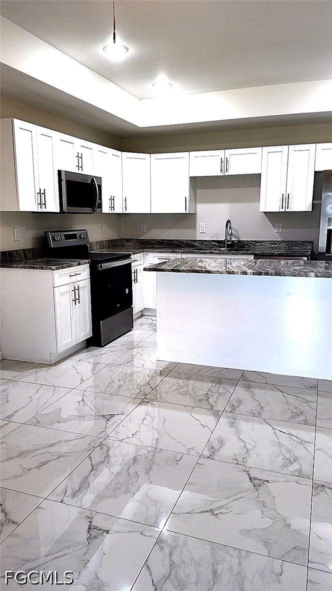 4518 14th Street Southwest Lehigh Acres, FL 33973 - Photo 3 of 6 a large kitchen with granite countertop a stove a sink and a microwave
