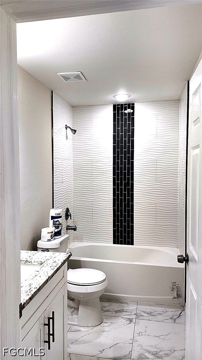4518 14th Street Southwest Lehigh Acres, FL 33973 - Photo 4 of 6 a bathroom with a granite countertop sink toilet a mirror and bathtub
