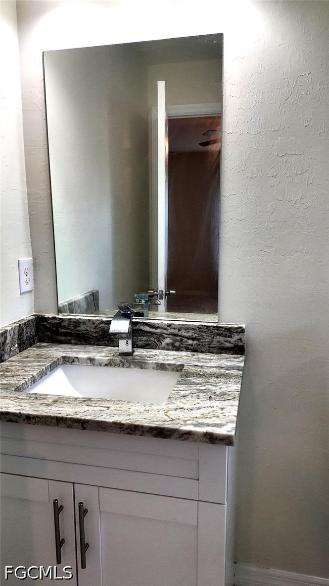4518 14th Street Southwest Lehigh Acres, FL 33973 - Photo 5 of 6 a bathroom with a granite countertop sink and a mirror