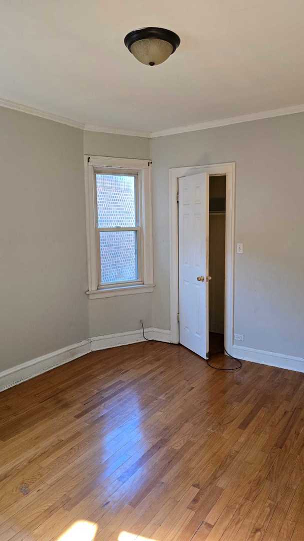 9417 South Racine Avenue Chicago, IL 60620 - Photo 5 of 9 an empty room with wooden floor and windows