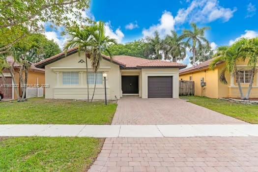 4127 Northeast 30th Street Homestead, FL 33033 - Photo 1 of 50 a front view of a house with a garden and yard