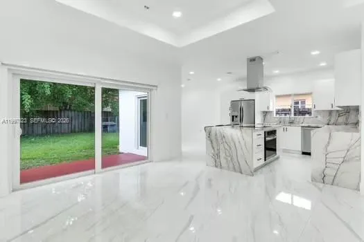 a kitchen with stainless steel appliances kitchen island granite countertop a sink and cabinets