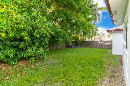 an aerial view of a residential houses with yard