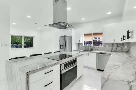 a kitchen with white cabinets and stainless steel appliances
