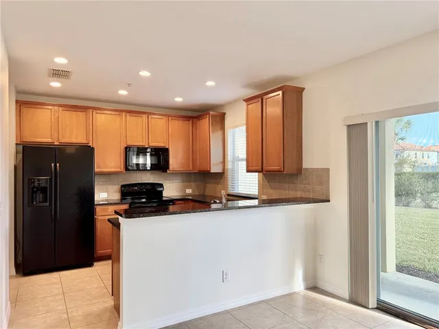 a kitchen with granite countertop stove top oven microwave and sink