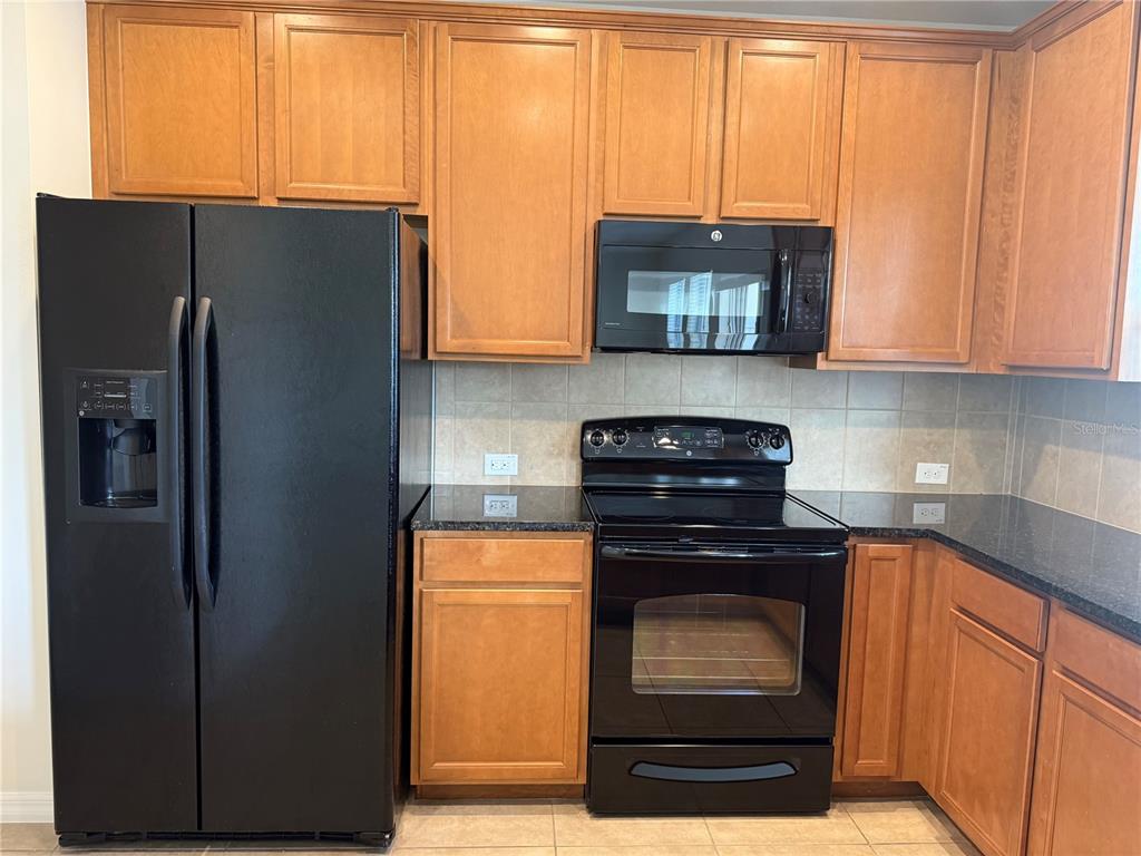 2090 Water Tupelo Way Ocoee, FL 34761 - Photo 4 of 43 a kitchen with stainless steel appliances granite countertop a refrigerator and a stove top oven