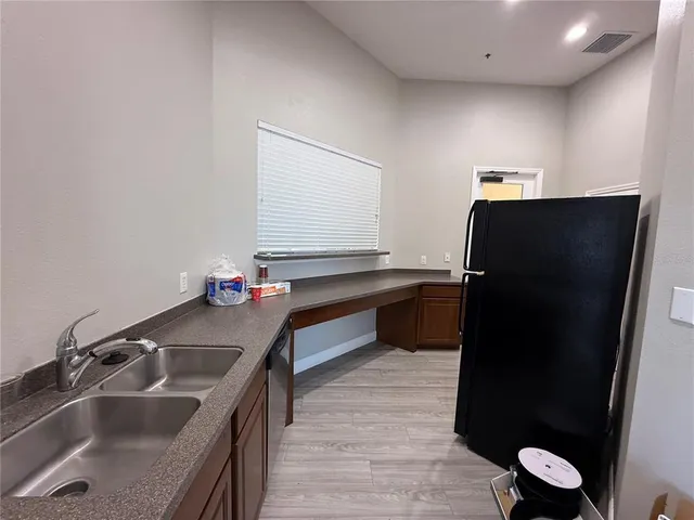 a kitchen with stainless steel appliances a refrigerator a sink a stove and wooden floor