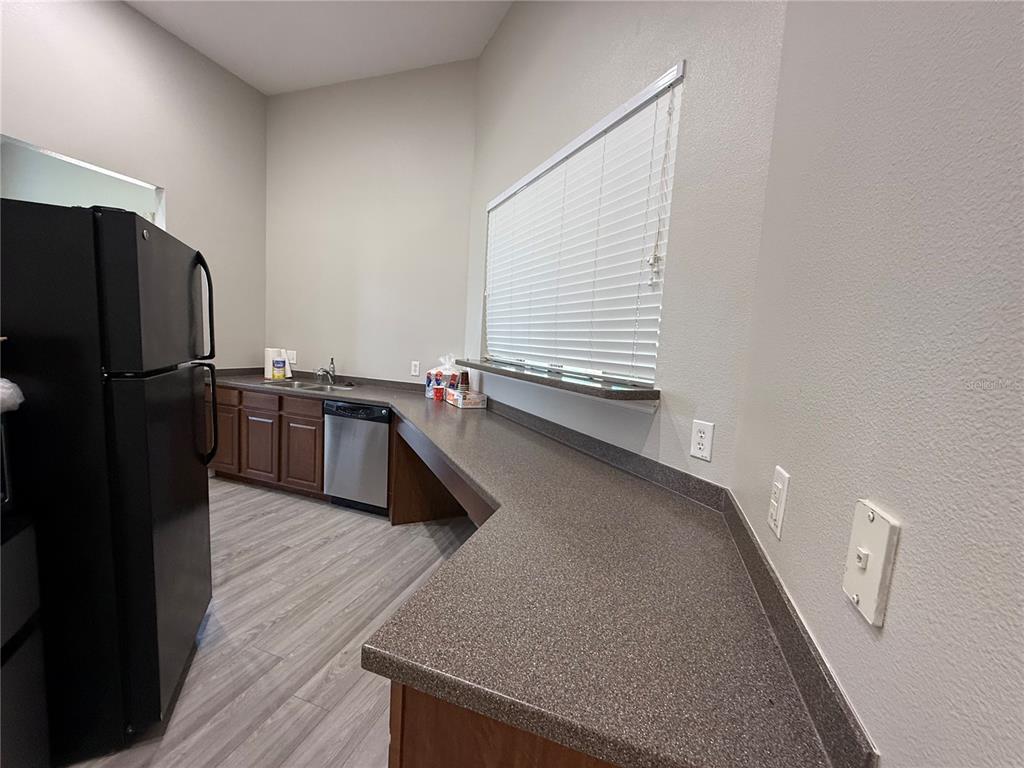 2090 Water Tupelo Way Ocoee, FL 34761 - Photo 42 of 43 a kitchen with stainless steel appliances a refrigerator a sink a stove and wooden floor