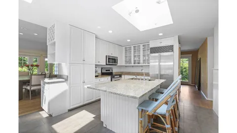 a kitchen with a table chairs refrigerator and cabinets