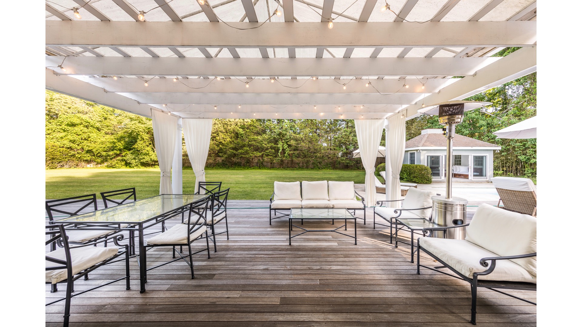 5 Ranch Court Sagaponack, NY 11962 - Photo 23 of 30 a view of a patio with table and chairs potted plants with wooden floor and fence