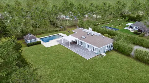 an aerial view of residential house with outdoor space and trees all around
