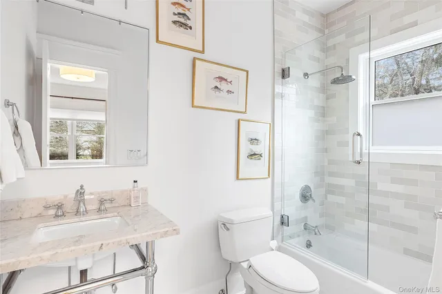 a bathroom with a granite countertop sink toilet a mirror and shower
