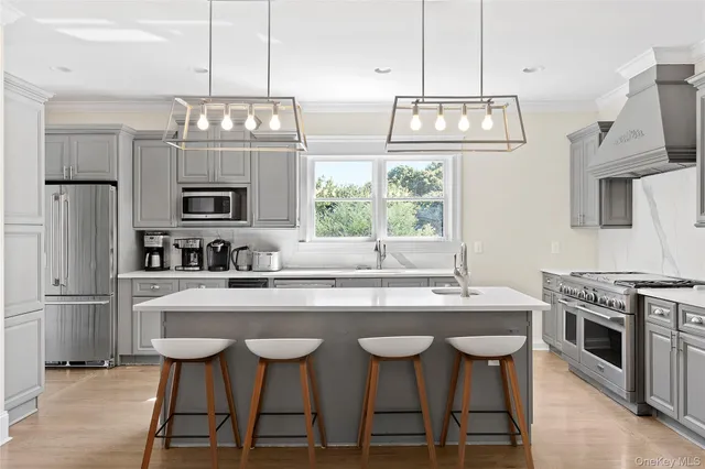 a kitchen with stainless steel appliances a stove a sink and a refrigerator